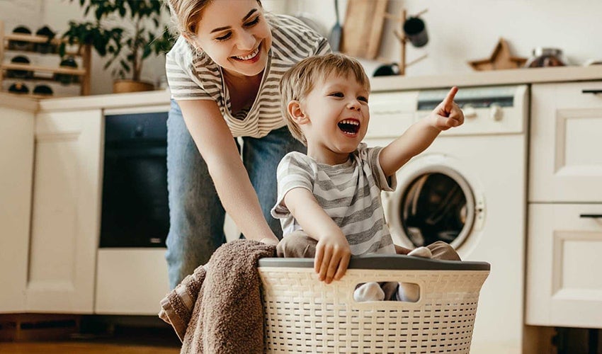 Woman and child playing in laundry room