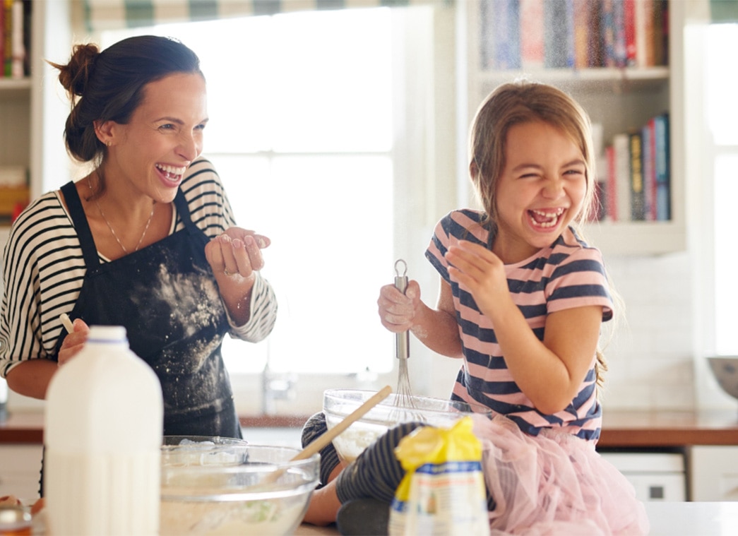 Mother and her daughter laughing in the kitchen