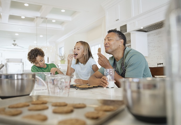 father and his children eating cookies as a family father and his children eating cookies as a family